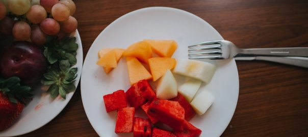 sliced watermelon and mango on plate with fork