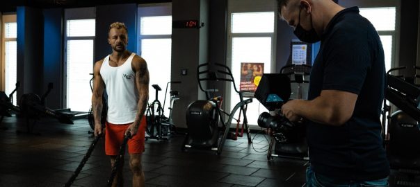 a man standing in a gym next to another man